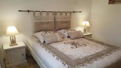 a bedroom with a bed with two lamps on tables at Les Prairies de l'Encrême in Céreste