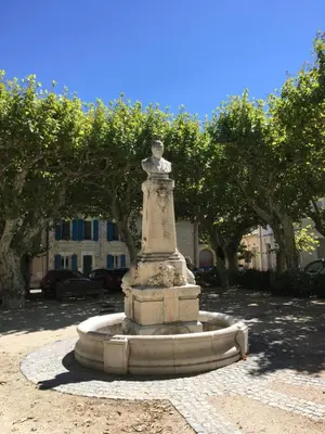a statue sitting in a fountain in a park at Maison de village Novissime in Noves