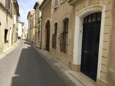 an empty alley with a black door on a building at Maison de village Novissime in Noves