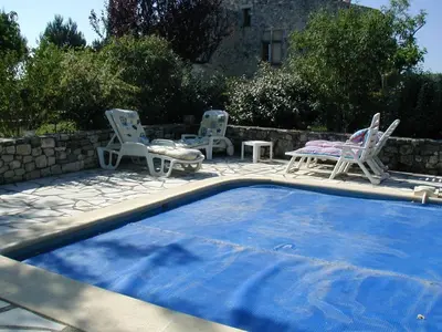 a swimming pool with two chairs and a table and chairs at La Fenice - Beautifully restored property with heated pool in small village in Montjustin