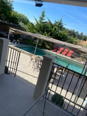 a balcony with chairs and a swimming pool at Villa Le Luberon in Mérindol