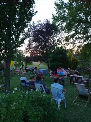a group of people sitting in chairs in a park at Mas de Karlotte in Pernes-les-Fontaines