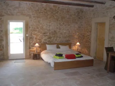 a bedroom with a bed and a stone wall at Château de Peyrolles in Apt