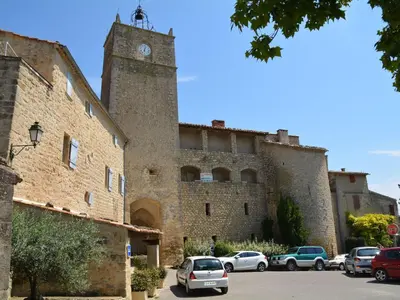 a large stone building with a clock tower at Provence Charm with Pool in Viens