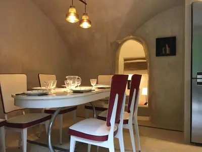 a dining room with a white table and chairs at La Calade, maison de village in Gordes
