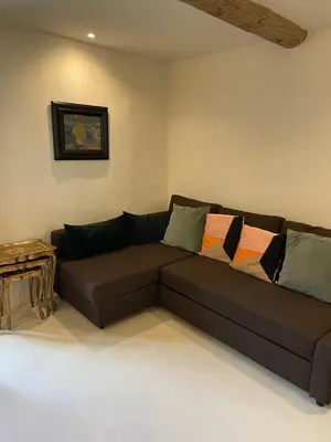 a brown couch in a living room with a table at La Calade, maison de village in Gordes