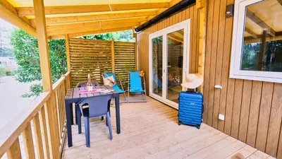 a patio with a table and chairs on a deck at Domaine Les Chênes Blancs in Saint-Saturnin-les-Apt