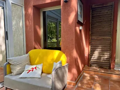 a yellow couch sitting on the porch of a house at Villa Melodie St Remy 6HA Piscine in Saint-Rémy-de-Provence