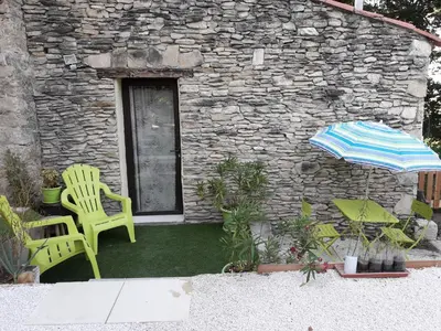 a patio with a yellow chair and an umbrella at Fleur des îles in Saint-Michel-lʼObservatoire