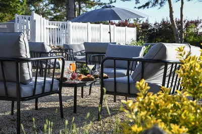 a group of chairs and a table and an umbrella at Domaine du Val de Sault in Sault-de-Vaucluse