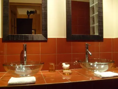 a bathroom with two glass bowls on a counter at Le Logis in Gordes