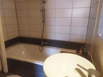 a bathroom with a tub and a toilet and a sink at Chambre d'hôtes face au lavoir in Méthamis