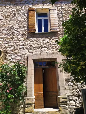 a stone building with a wooden door and a window at Chambre d'hôtes face au lavoir in Méthamis