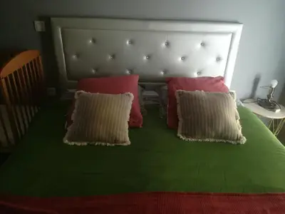 a bed with two pillows and a green blanket at Au pays du Ventoux in Le Thor