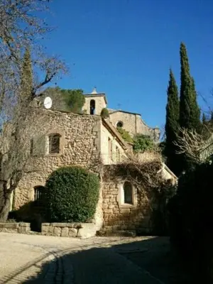 an old stone building with a clock on top of it at Gite des Taillades in Les Taillades