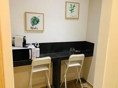 a kitchen with a black counter and two stools at Victoire Appartement in Aix-en-Provence