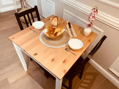 a wooden table with a plate of food on it at Victoire Appartement in Aix-en-Provence