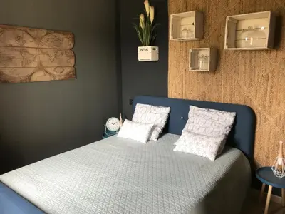 a bedroom with a blue bed with two pillows at Loft piscine et spa provence in LʼIsle-sur-la-Sorgue