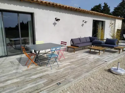 a patio with a table and chairs and a couch at Loft piscine et spa provence in LʼIsle-sur-la-Sorgue