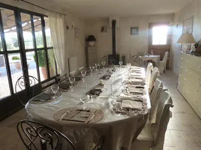 a long table with white table cloth and wine glasses at Mas Bastide st Victor à 5 mn de Lourmarin in Puyvert