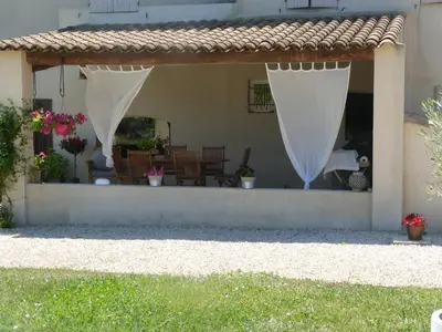 a patio with a white curtain on a house at Mas Bastide st Victor à 5 mn de Lourmarin in Puyvert
