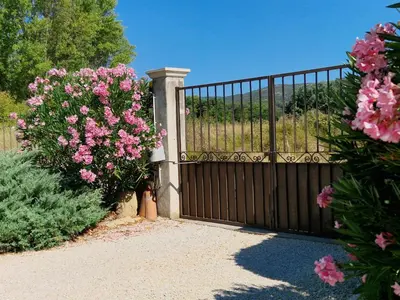 a wooden fence with pink flowers on it at La Parenthèse in Lauris