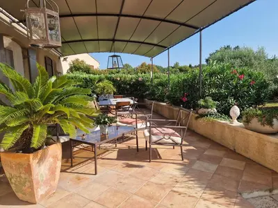a patio with tables and chairs under an umbrella at La Parenthèse in Lauris