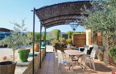 a patio with a table and chairs under a pergola at Lovely Home In Gordes With Kitchen in Gordes