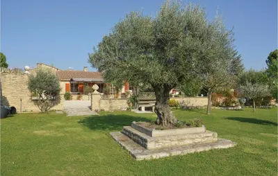 a tree in a yard in front of a house at Lovely Home In Gordes With Kitchen in Gordes
