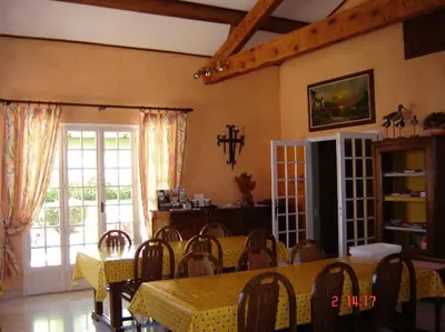 a dining room with a table and chairs and a window at Le Mas de l'Amandier in Saint-Saturnin-lès-Avignon