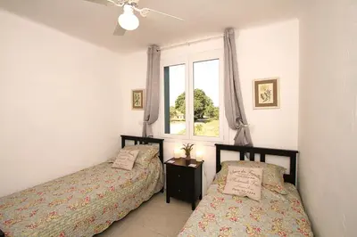 a bedroom with two beds and a window at L'Oustalado in Maubec