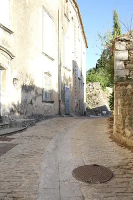 an empty street in front of a building at L'Oustalado in Maubec