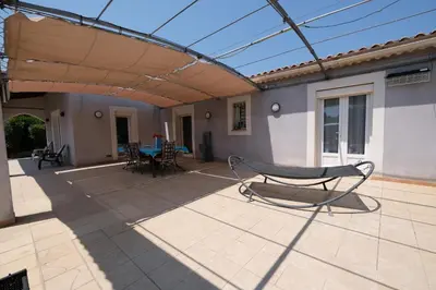 a patio with awning and a table and chairs at pleasant one-level villa with private pool in the thor village, close to l'isle sur la sorgue - 6 persons in Le Thor