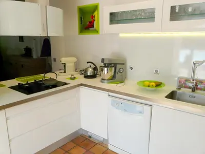 a kitchen with white cabinets and a bowl of fruit on the counter at pleasant one-level villa with private pool in the thor village, close to l'isle sur la sorgue - 6 persons in Le Thor