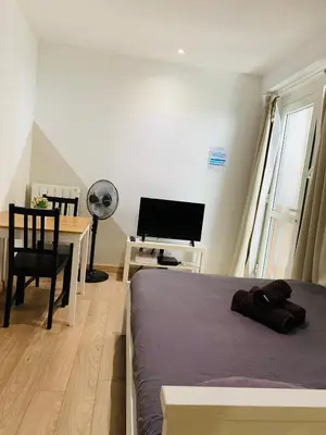 a bedroom with a bed and a desk with a television at Cassis Studio in Aix-en-Provence