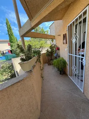 a porch with potted plants on the side of a house at Appartement 