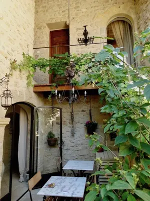 a patio with a table in front of a building at Un Patio en Luberon in Ansouis