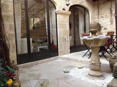 a stone courtyard with a fountain in a building at Un Patio en Luberon in Ansouis