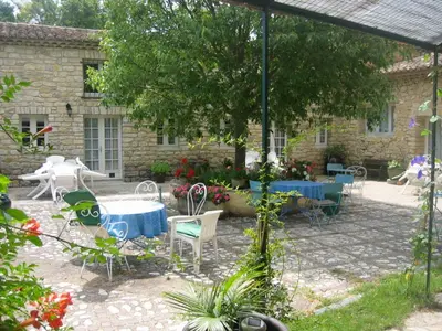 a patio with a table and chairs in front of a building at Moulin d'Antelon B&B in Crillon-le-Brave