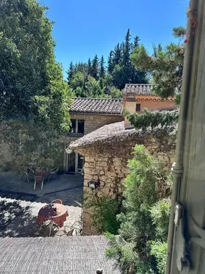 an outside view of a stone house with a patio at Moulin d'Antelon B&B in Crillon-le-Brave