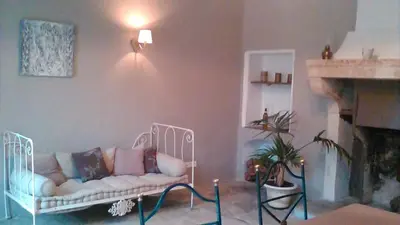 a living room with a couch and a fireplace at Le Temps d'un Rêve in Mazan