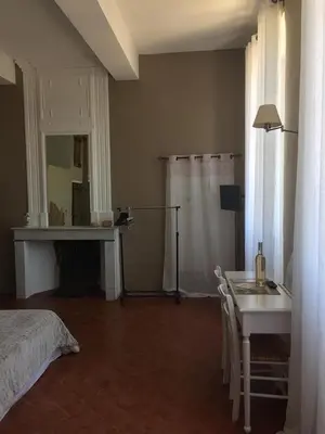 a bedroom with a bed and a table and a bed and a table and chairs at Le Temps d'un Rêve in Mazan
