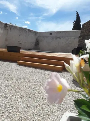 a garden with wooden planks on a concrete wall at Le Temps d'un Rêve in Mazan