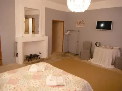 a bedroom with a bed and a chandelier at Le Temps d'un Rêve in Mazan