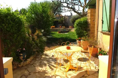 a patio with a table and chairs in a yard at Gite le Mas de l'Amandier in Saint-Saturnin-lès-Avignon