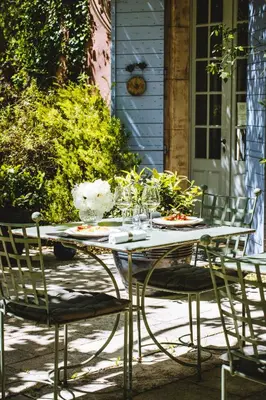 a table with chairs and plates of food on it at Bastide Rose in Le Thor