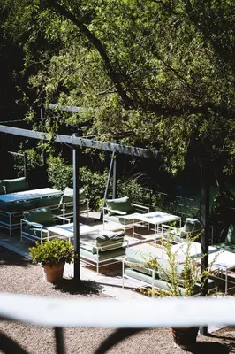 a group of tables and chairs under a tree at Bastide Rose in Le Thor