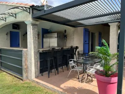 a patio with a kitchen and a table and chairs at Chez Frédérique et Jean-Claude in Les Taillades
