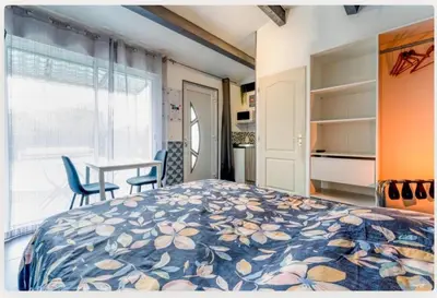 a bedroom with a bed and a table and a window at Chez Frédérique et Jean-Claude in Les Taillades