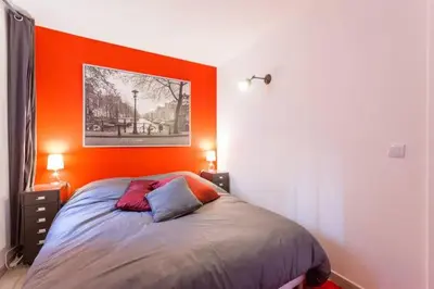 a bedroom with a bed with an orange headboard at L'Entrecasteaux in Aix-en-Provence